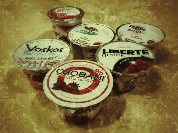 Several brands of Greek yogurt with strawberries